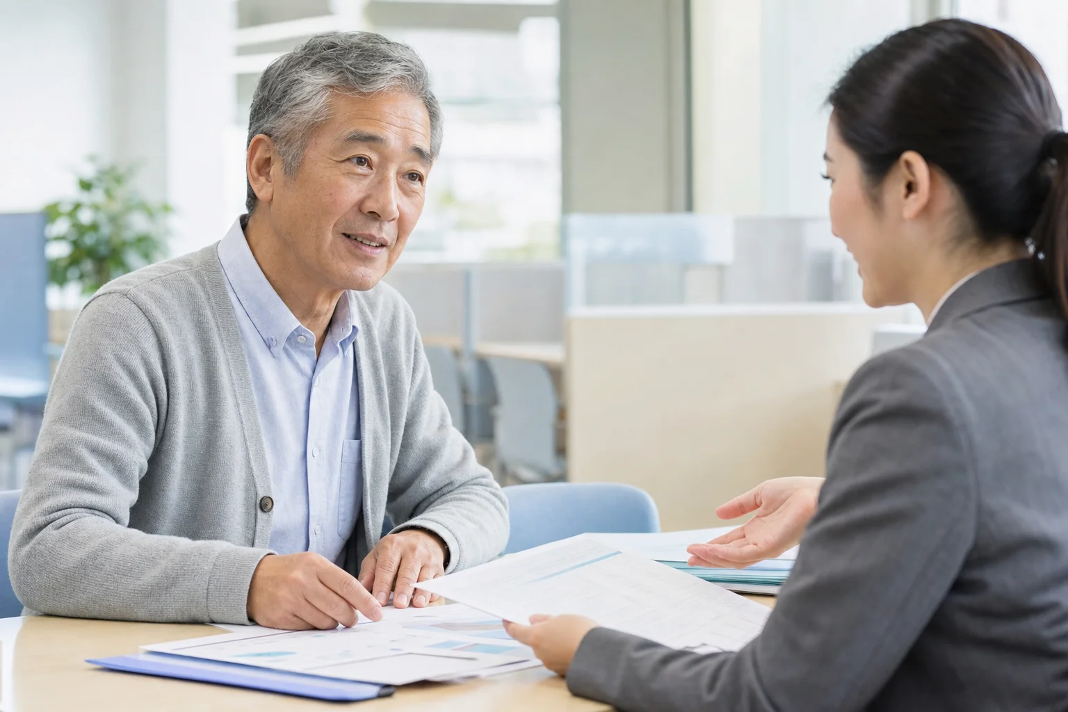 ハローワークの窓口で相談する65歳前後のシニアの様子。落ち着いた雰囲気