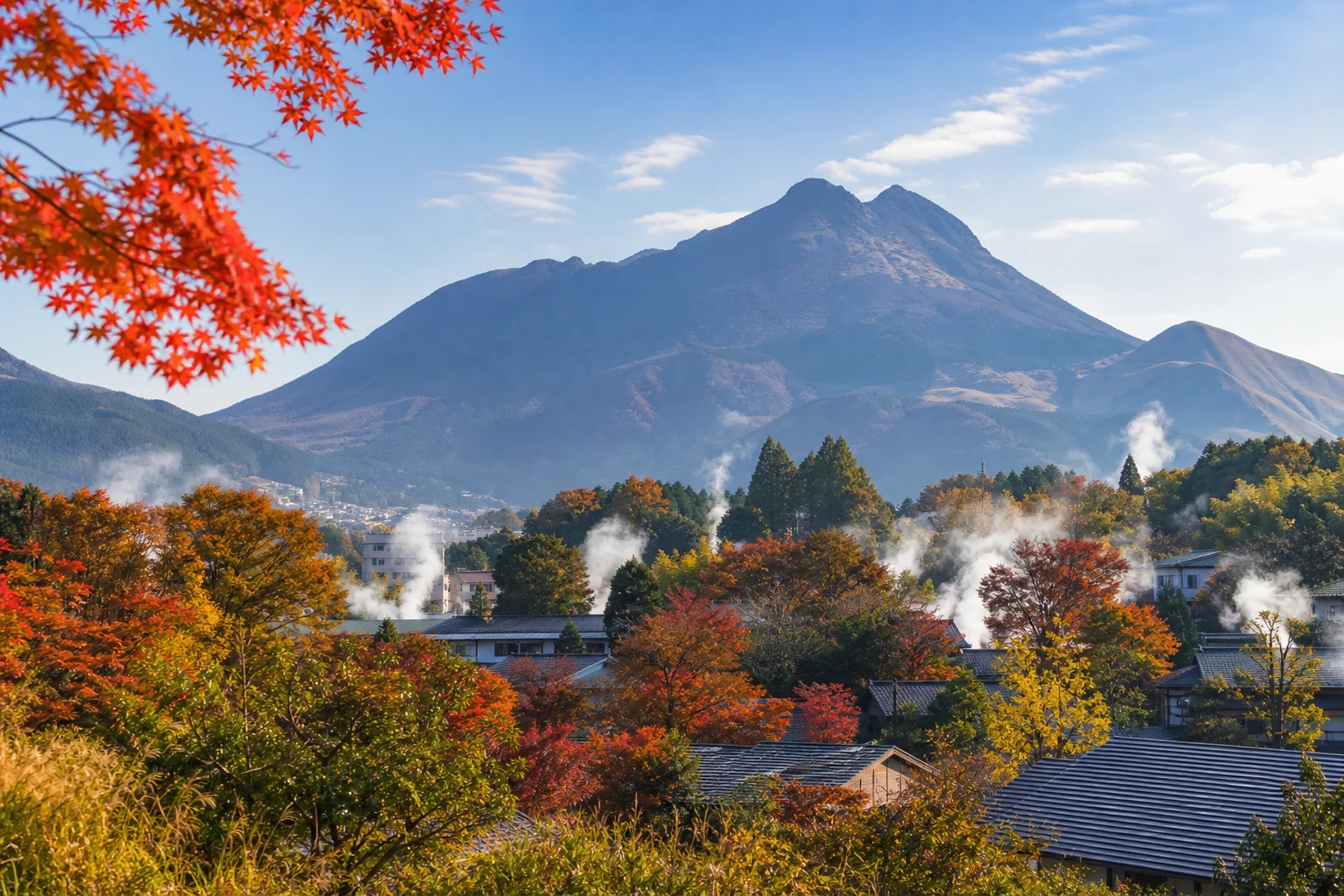 由布院の秋、由布岳を背景に湯けむりが立つ温泉郷の風景